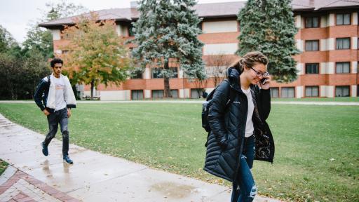 Student walking on campus talking on the phone